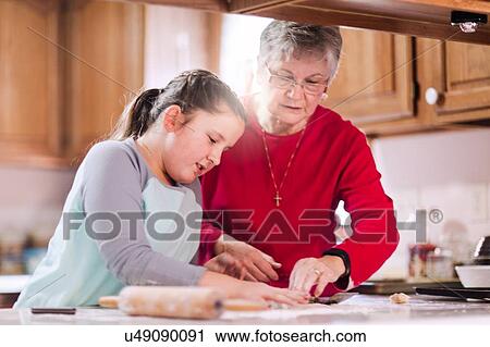 Girl and grandmother using cookie cutter on dough at kitchen counter View Large Photo Image Stock Image - Girl and grandmother using cookie cutter on dough at kitchen counter. Fotosearch
