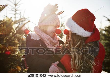 Girl and mother in christmas tree forest wearing red noses View Large Photo Image Stock Image - Girl and mother in christmas tree forest wearing red noses. Fotosearch