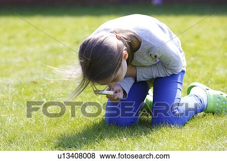 Girl examining grass with a magnifying glass. View Large Photo Image Stock Photo - Girl examining grass with a magnifying glass.. Fotosearch