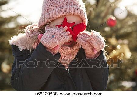 Girl in christmas tree forest covering her eyes with christmas decorations View Large Photo Image Stock Photo - Girl in christmas tree forest covering her eyes with christmas decorations. Fotosearch