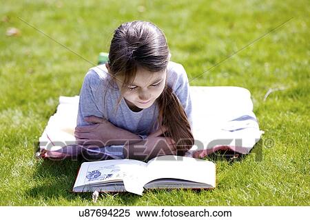 Girl lying on grass reading. View Large Photo Image Stock Photography - Girl lying on grass reading.. Fotosearch