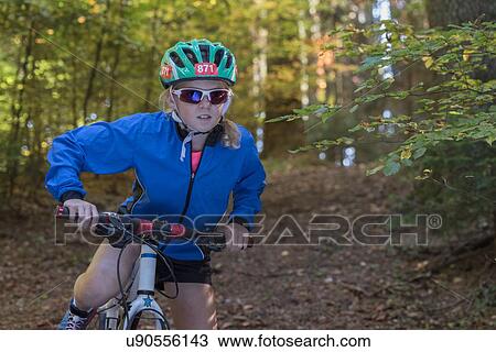 Girl mountain biker preparing to cycle in woodland View Large Photo Image Stock Image - Girl mountain biker preparing to cycle in woodland. Fotosearch