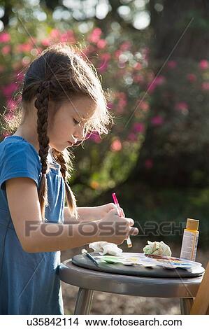 Picture - Girl preparing paint palette in garden. Fotosearch