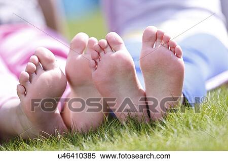 Stock Photography - Girls' bare feet on grass.. Fotosearch
