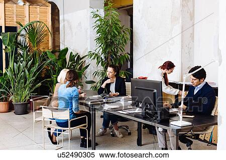 Group of of businesspeople working in office, three women in conversation at desk View Large Photo Image Stock Photography - Group of of businesspeople working in office, three women in conversation at desk. Fotosearch