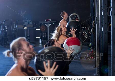 Group of people exercising in gym, using medicine balls View Large Photo Image Stock Photo - Group of people exercising in gym, using medicine balls. Fotosearch