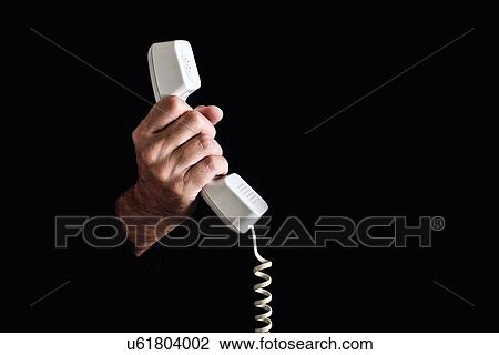 Stock Image - Hand holding telephone receiver.. Fotosearch