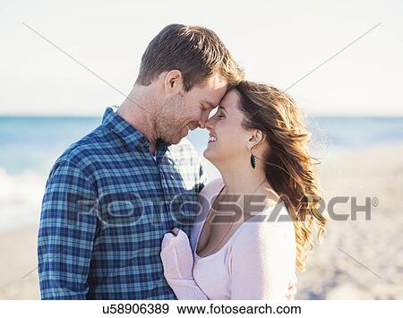 Stock Photo - Happy couple in beach, face to face. Fotosearch