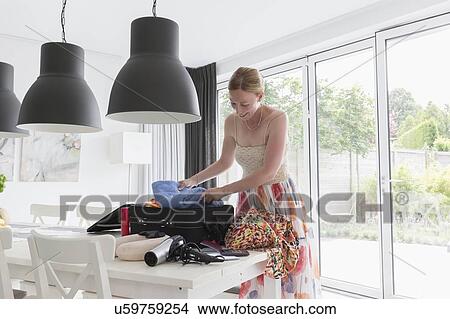Happy mature woman packing suitcase for vacations View Large Photo Image Picture - Happy mature woman packing suitcase for vacations. Fotosearch