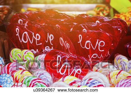 Stock Photo - Heart shaped lollipop with word Love on street market.. Fotosearch