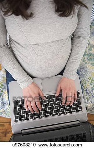 High angle view of pregnant woman using laptop View Large Photo Image Stock Image - High angle view of pregnant woman using laptop. Fotosearch