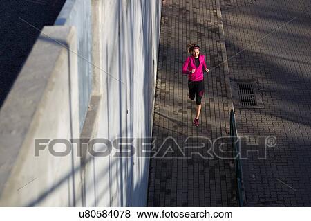 Stock Photo - High angle view of young woman jogging. Fotosearch