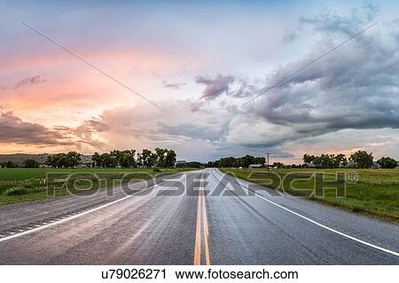 Stock Image - Highway through rural area, Montana, US. Fotosearch