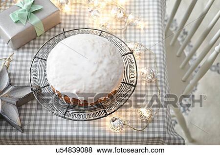 Stock Photo - Iced cake on table with decorative lights. Fotosearch