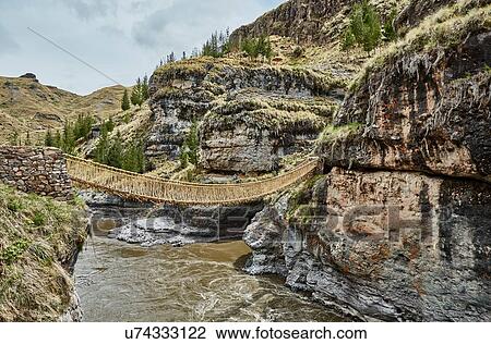 Stock Image - Inca rope bridge crossing river ravine, Huinchiri, Cusco, Peru. Fotosearch