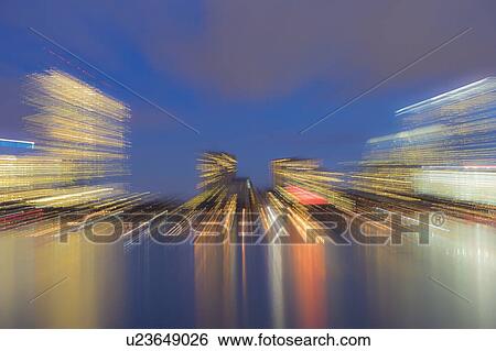 Stock Photograph - Light trails from city skyline at dusk. Fotosearch