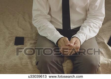 Lonely businessman in hotel room sitting on the bed. View Large Photo Image Stock Image - Lonely businessman in hotel room sitting on the bed.. Fotosearch