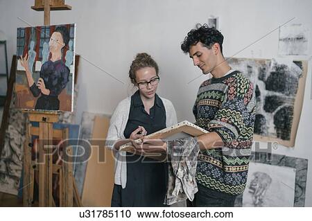 Male artist and female client looking at canvas in artists studio View Large Photo Image Stock Image - Male artist and female client looking at canvas in artists studio. Fotosearch