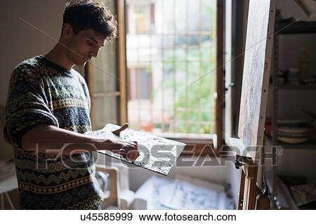 Male artist applying oil paint to palette in artists studio View Large Photo Image Stock Photo - Male artist applying oil paint to palette in artists studio. Fotosearch