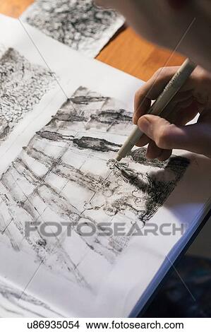 Male artist drawing in sketchbook in artists studio, over shoulder view View Large Photo Image Picture - Male artist drawing in sketchbook in artists studio, over shoulder view. Fotosearch