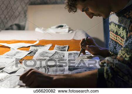 Stock Image - Male artist drawing in sketchbook in artists studio. Fotosearch