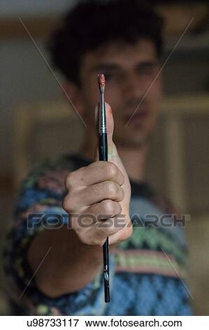 Male artist holding paintbrush in artists studio, close up View Large Photo Image Stock Photo - Male artist holding paintbrush in artists studio, close up. Fotosearch