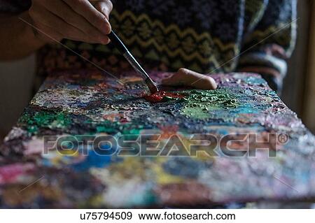 Male artist mixing oil paint on palette in artists studio, close up detail View Large Photo Image Stock Photo - Male artist mixing oil paint on palette in artists studio, close up detail. Fotosearch