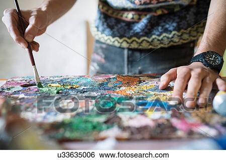 Male artist mixing oil paint on palette in artists studio, close up of hands View Large Photo Image Stock Photograph - Male artist mixing oil paint on palette in artists studio, close up of hands. Fotosearch