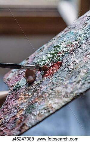 Stock Photo - Male artist mixing oil paint on palette, close up. Fotosearch