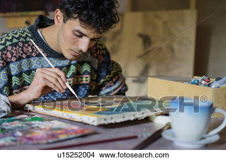 Picture - Male artist painting canvas in artists studio, cropped. Fotosearch
