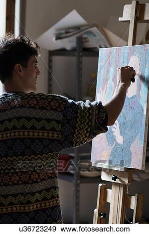 Stock Photo - Male artist painting canvas in artists studio. Fotosearch