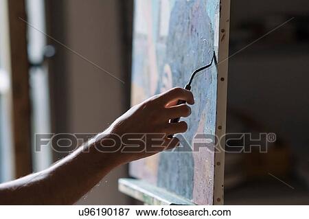Male artist painting canvas in artists studio, detail of hand View Large Photo Image Stock Photo - Male artist painting canvas in artists studio, detail of hand. Fotosearch