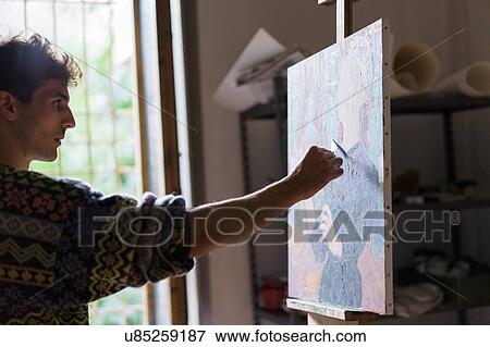 Male artist painting canvas on easel in artists studio View Large Photo Image Stock Photo - Male artist painting canvas on easel in artists studio. Fotosearch