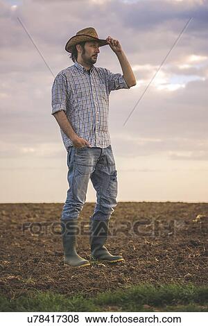 Male farmer standing on farmland. View Large Photo Image Stock Photo - Male farmer standing on farmland.. Fotosearch