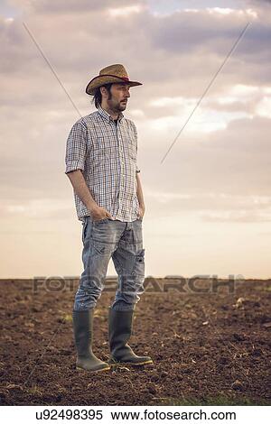 Stock Photography - Male farmer standing on farmland.. Fotosearch