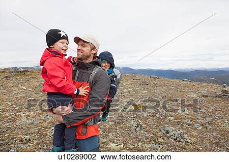 Stock Image - Male hiker with sons in mountain landscape, Jotunheimen National Park, Lom, Oppland, Norway. Fotosearch