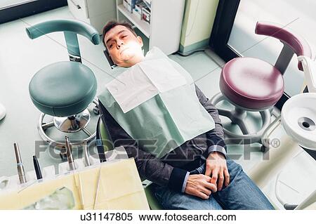 Stock Photography - Male patient in dentist chair, elevated view. Fotosearch