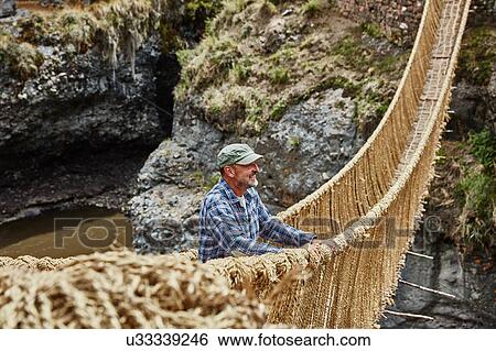 Male tourist looking out from Inca rope bridge, Huinchiri, Cusco, Peru View Large Photo Image Stock Photograph - Male tourist looking out from Inca rope bridge, Huinchiri, Cusco, Peru. Fotosearch