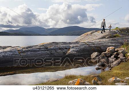 Man and son walking on fjord rock formation, Aure, More og Romsdal, Norway View Large Photo Image Stock Photography - Man and son walking on fjord rock formation, Aure, More og Romsdal, Norway. Fotosearch