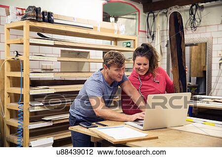 Man and woman in workshop, using laptop View Large Photo Image Stock Image - Man and woman in workshop, using laptop. Fotosearch