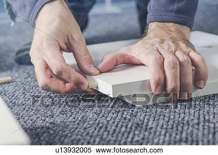 Man assembling furniture at home, hand with dowel pins. View Large Photo Image Stock Photography - Man assembling furniture at home, hand with dowel pins.. Fotosearch