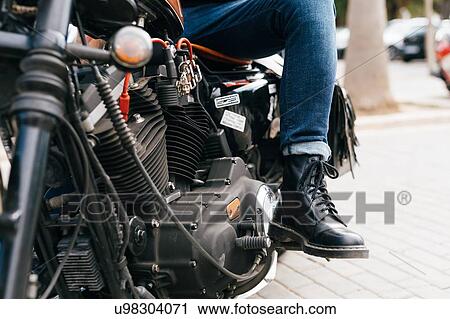 Stock Image - Man astride motorcycle, cropped. Fotosearch