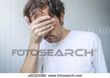 Stock Photography - Man covering face and crying.. Fotosearch