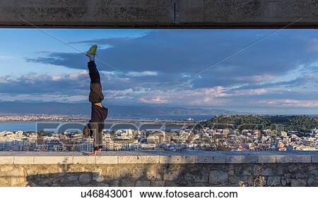 Man doing handstand on wall, Cagliari, Sardinia, Italy View Large Photo Image Stock Image - Man doing handstand on wall, Cagliari, Sardinia, Italy. Fotosearch