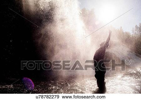 Stock Photo - Man enjoying waterfall spray, Ural, Sverdlovsk, Russia. Fotosearch