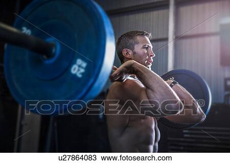 Man exercising in gym, using barbell, front squat position View Large Photo Image Stock Image - Man exercising in gym, using barbell, front squat position. Fotosearch