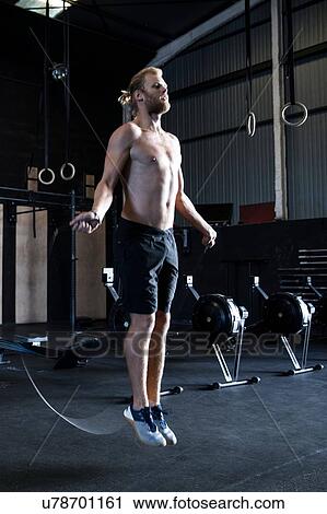 Man exercising in gymnasium, skipping with speed rope View Large Photo Image Stock Image - Man exercising in gymnasium, skipping with speed rope. Fotosearch