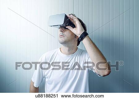 Stock Image - Man exploring virtual reality environment.. Fotosearch