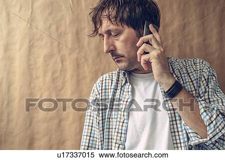 Stock Photography - Man hearing bad news on the phone.. Fotosearch