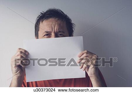 Man hiding behind blank white paper. View Large Photo Image Picture - Man hiding behind blank white paper.. Fotosearch